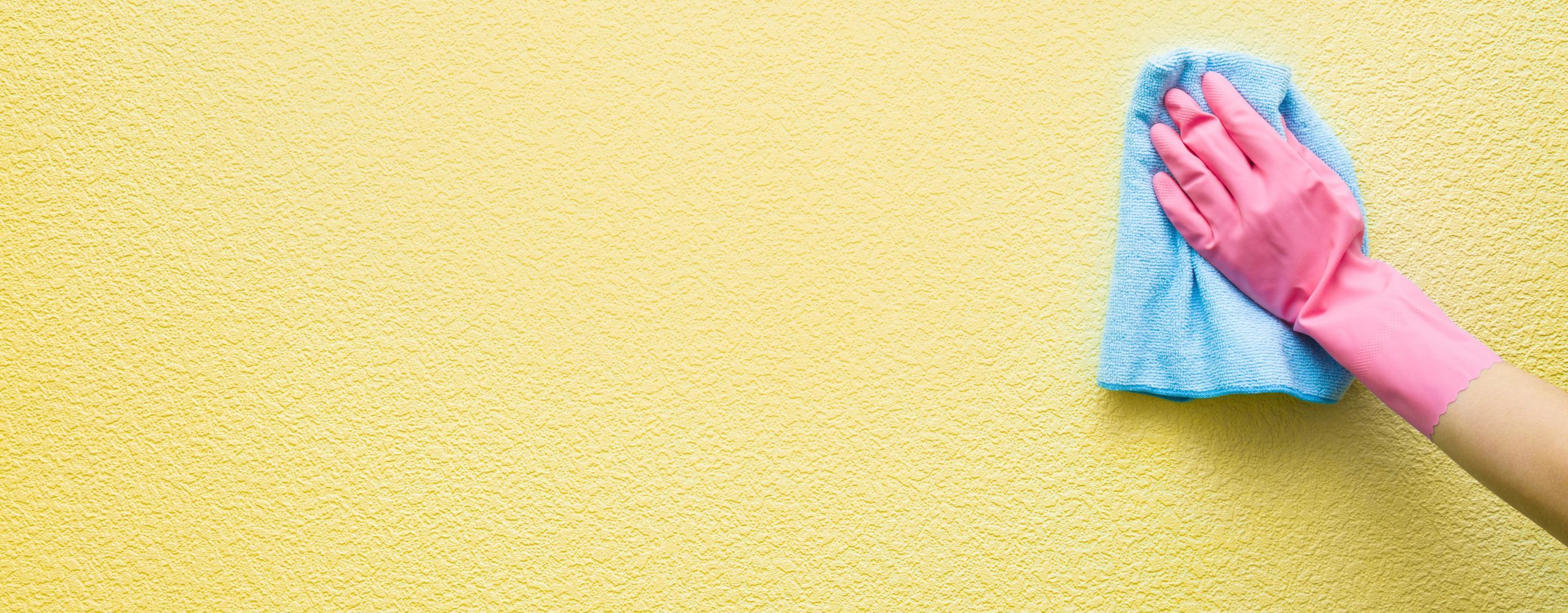 person cleaning interior walls with a rag