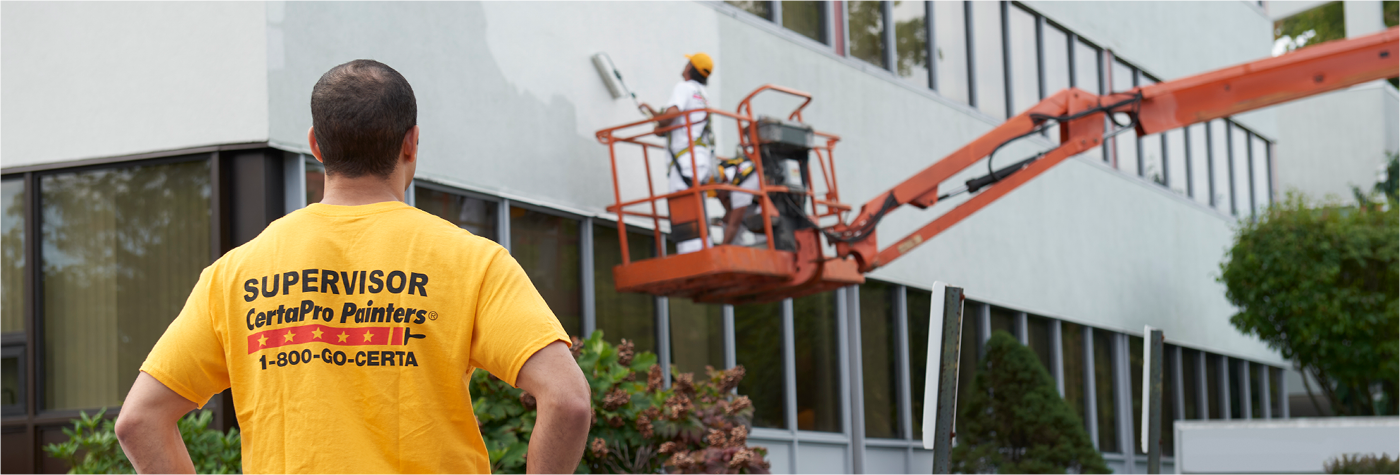 CertaPro Painter Supervisor watching CertaPro Painter on crane.