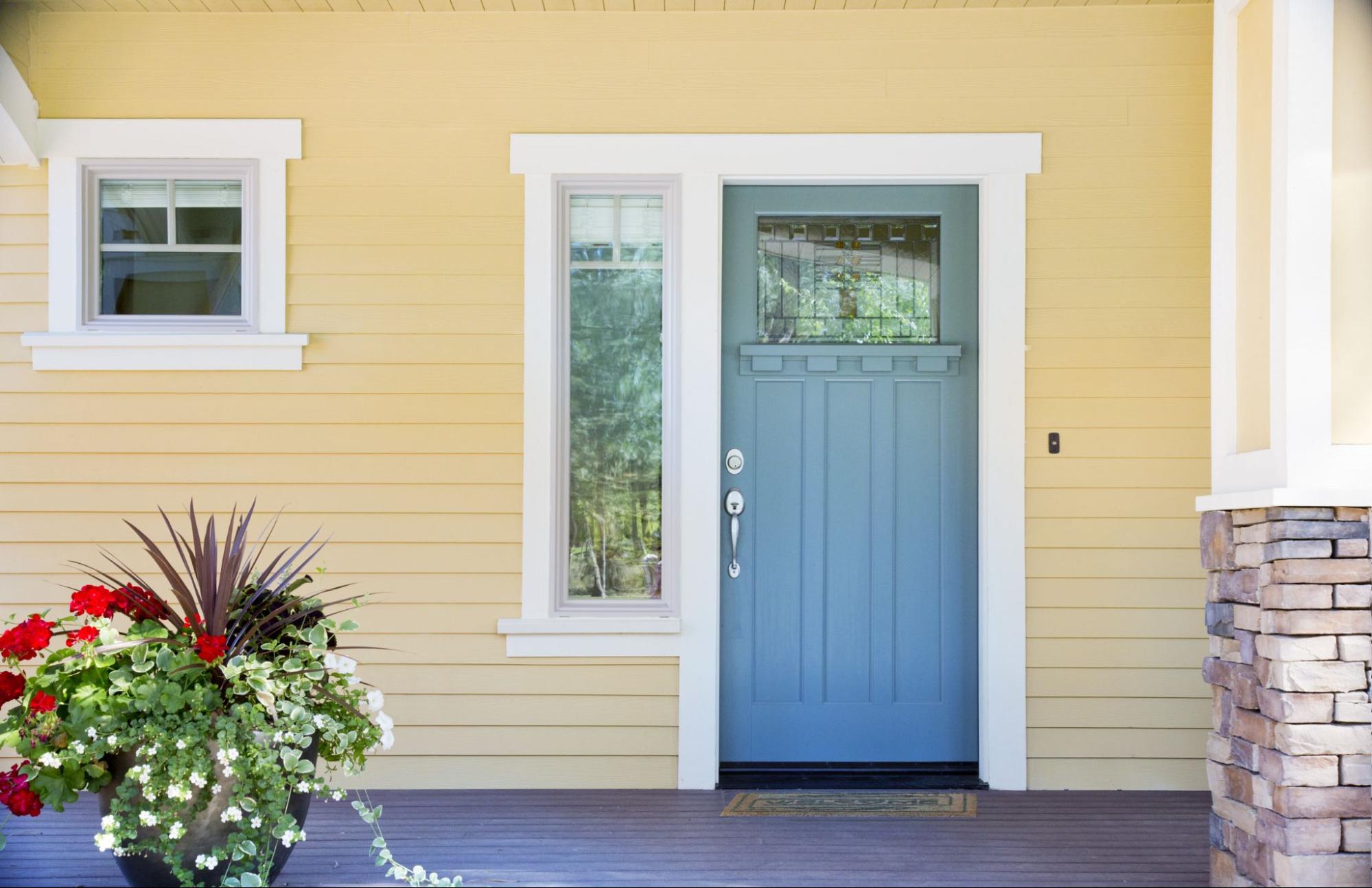 Yellow house with a light blue door and white exterior molding