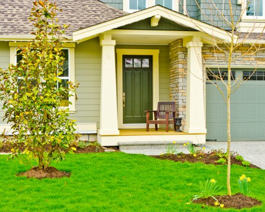 A suburban home with brick detail and a dark green front door