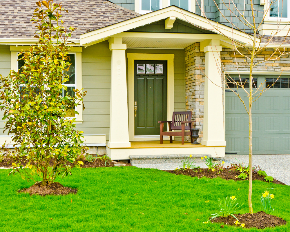 A suburban home with brick detail and a dark green front door