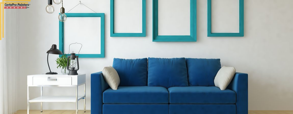 blue couch in front of white wall with empty teal frames