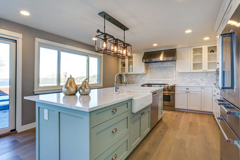 interior of kitchen showing large island with painted cabinets