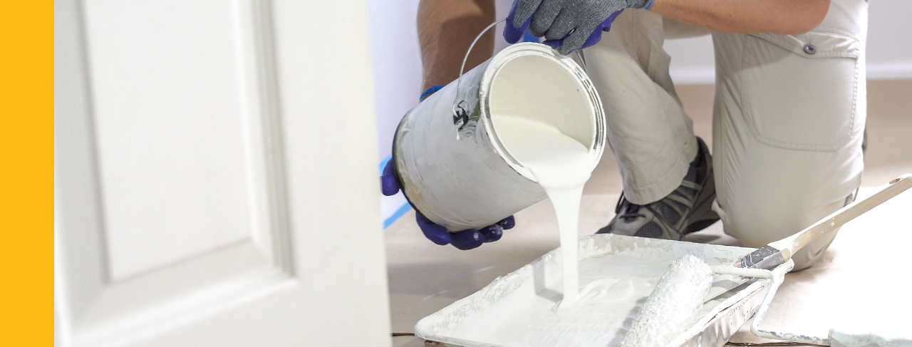 Professional painter pouring white paint