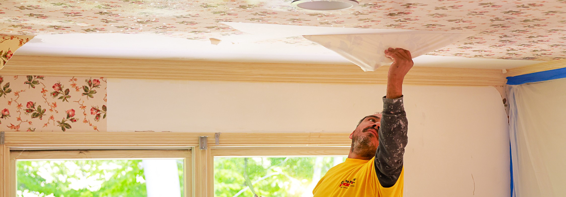 CertaPro Painters professionals removing wallpaper from a ceiling