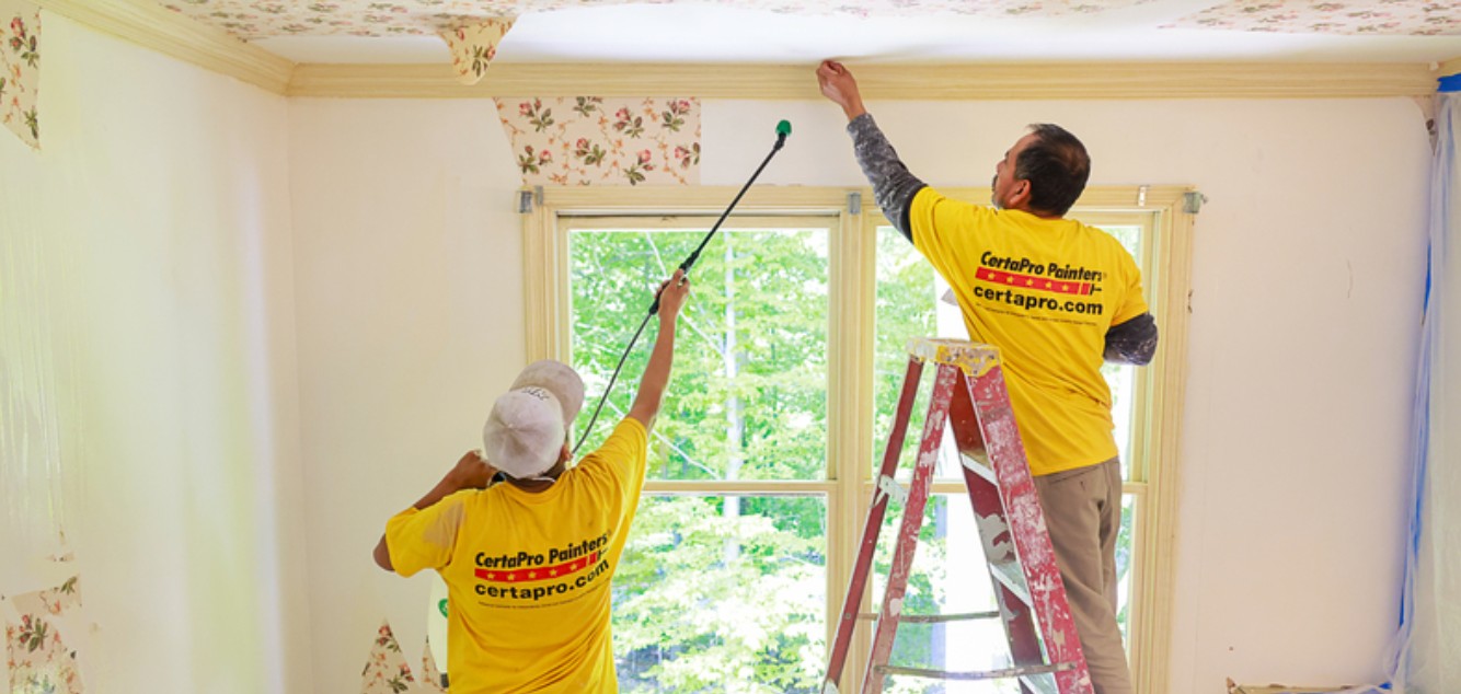 CertaPro Painters professionals removing floral wallpaper from a room