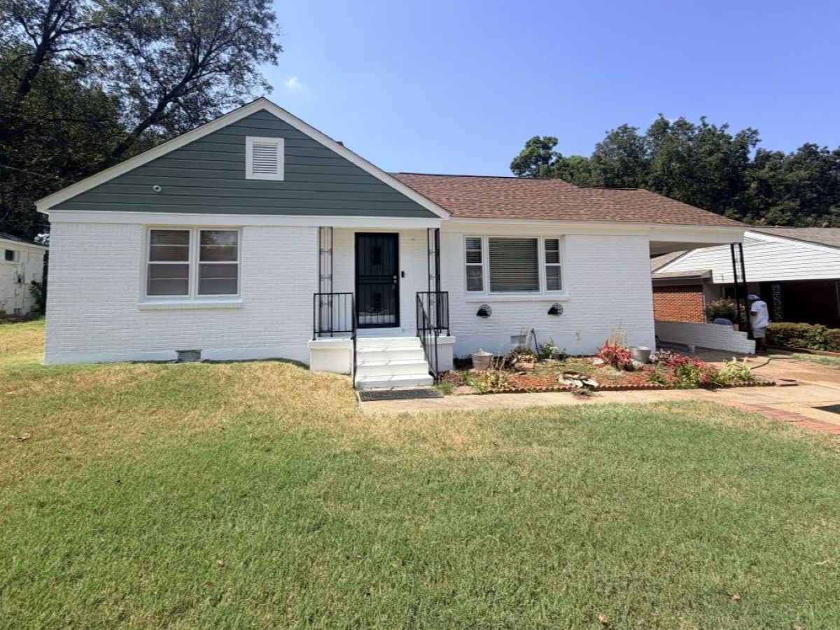 brick house exterior painted white with green accent siding