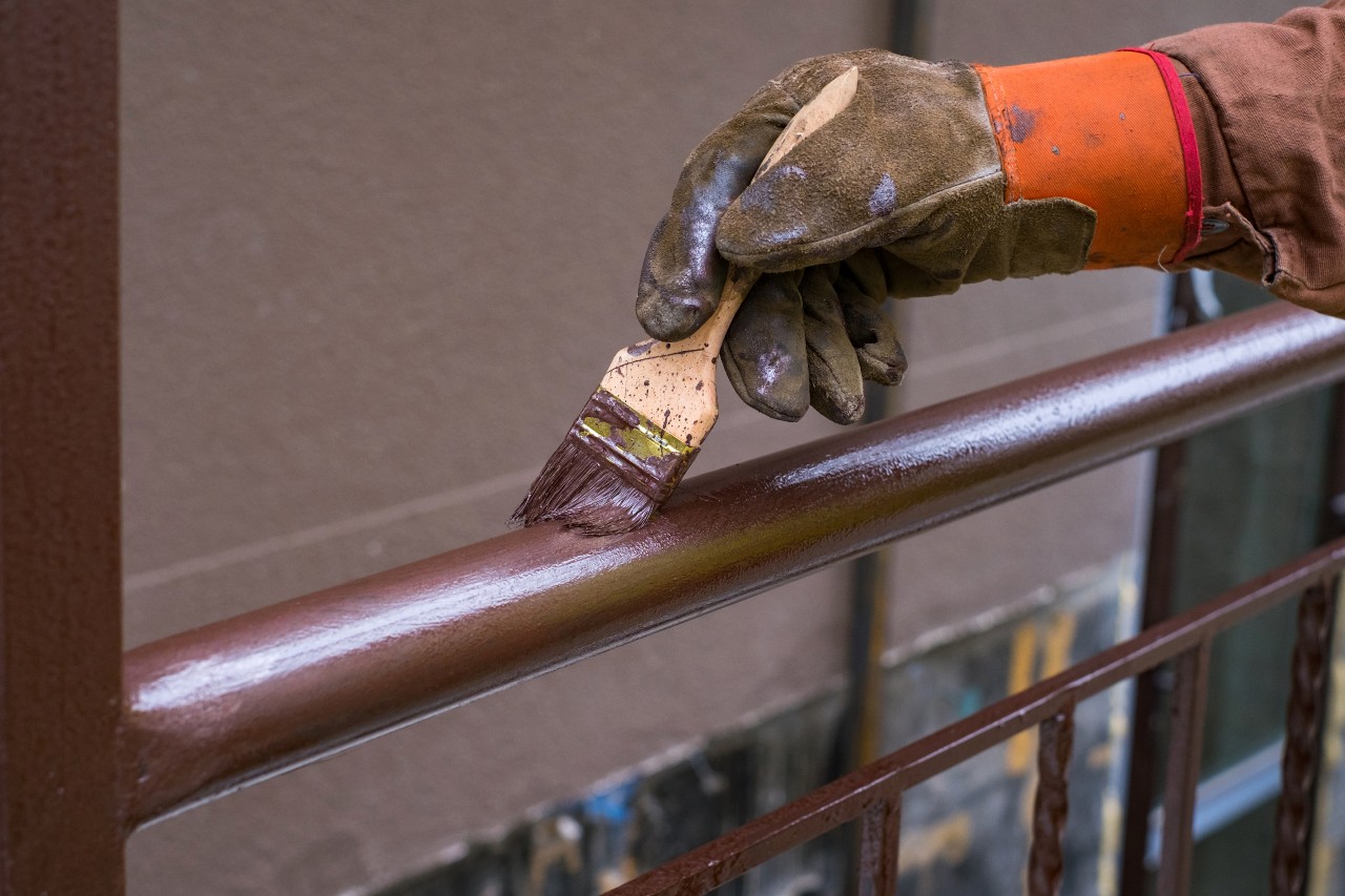 Railing getting painted brown by painter