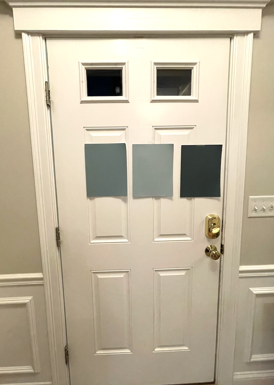 Door with three paper paint samples taped to it