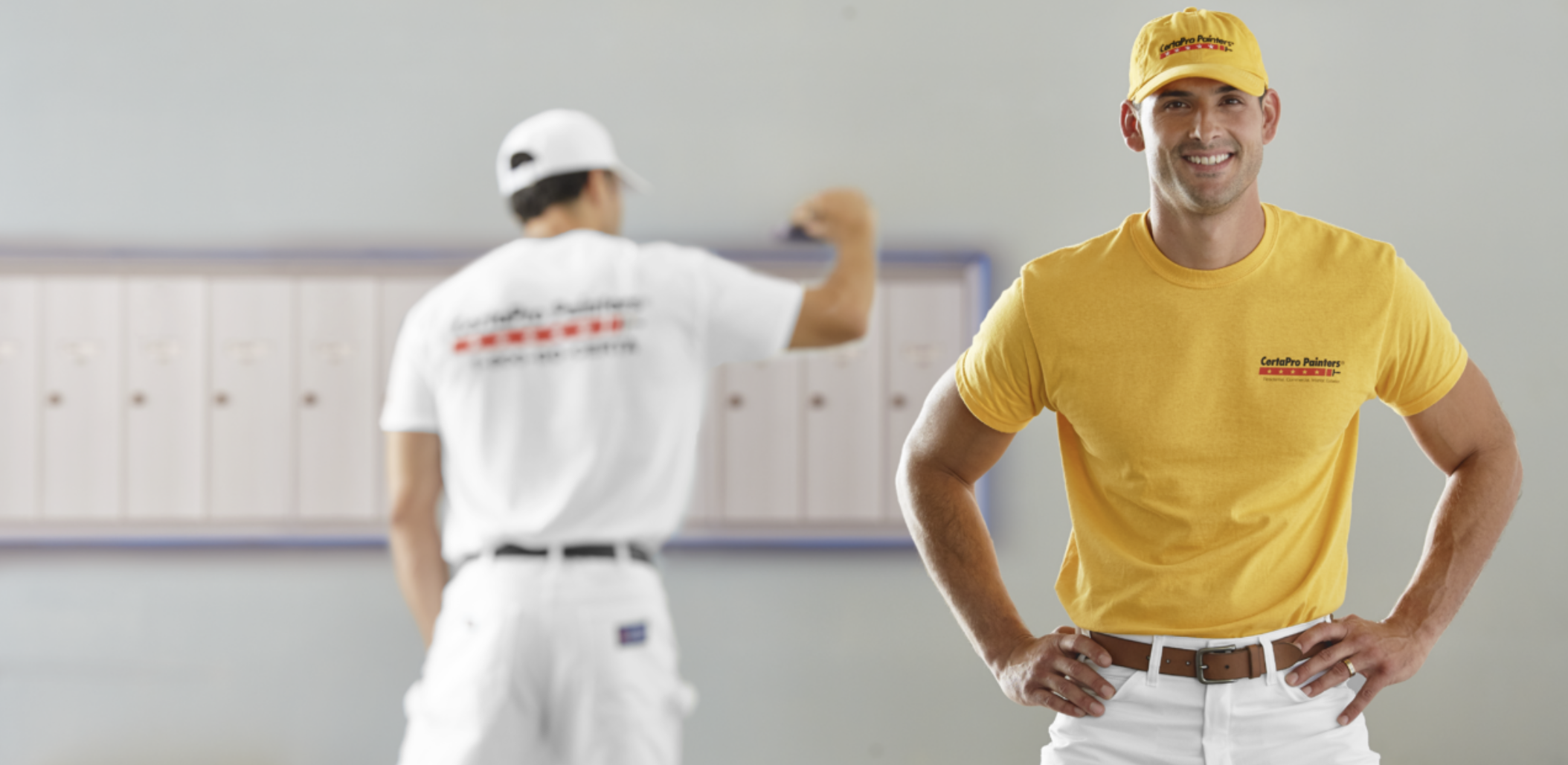 Painter painting a wall with a supervisor in the foreground