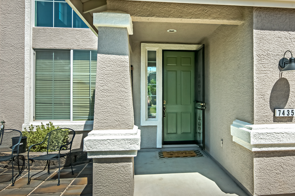 entrance to stucco home painted in two contrasting shades of tan.