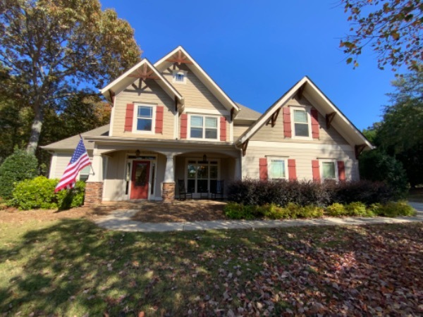 House with beige siding and red shutters