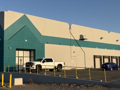 front of industrial building painted off white with teal accent