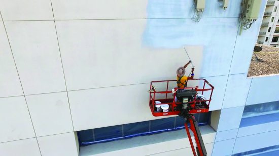 painter painting the exterior of an office bulding