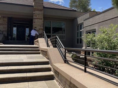 stone paved entrance and steps with painted metal railing