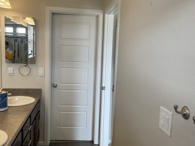 home bathroom with double sink and white painted doors