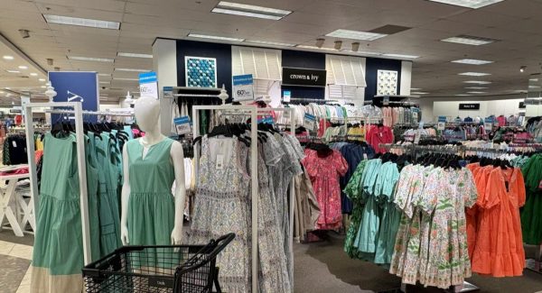 Crown & Ivy dress displays with white walls and navy accent wall after Charleston department store interior painting.