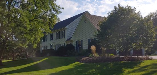 Two-story bright white house in Palatine, IL featuring crisp white trim and contrasting black window shutters.