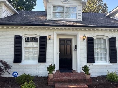 white painted brick house with black accents and trim
