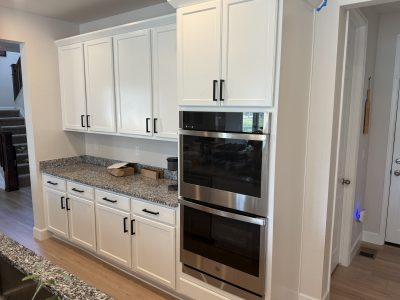 white painted kitchen cabinets with black hardware after repaint