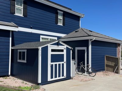 house and detached shed with blue siding