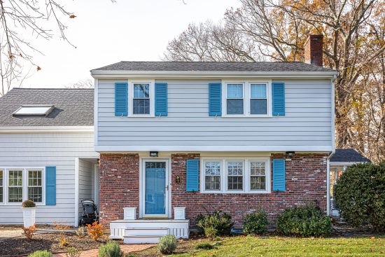 blue painted front door and shutters on gray siding home