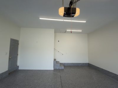 empty home garage with finished drywall and coated floors