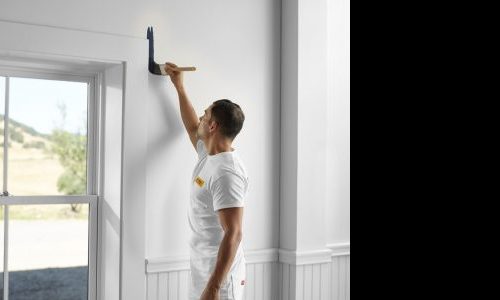 Man Applying Paint Near Window