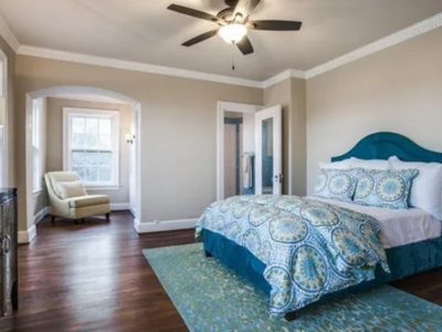 beige painted bedroom with bed and armchair