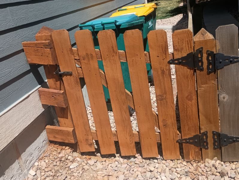 stained fence gate surrounding refuse bins against house Preview Image 2