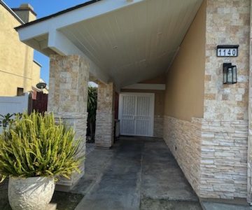 Stone and stucco home repainted in a medium tan.