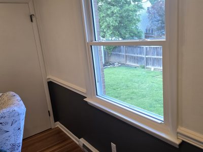 home hallway with walls painted dark and white, separated with trim