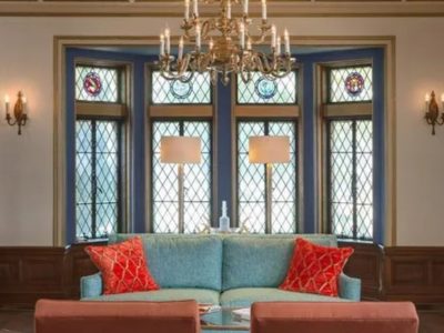 blue couch in front of tall blue trimmed windows with diamond grid pattern