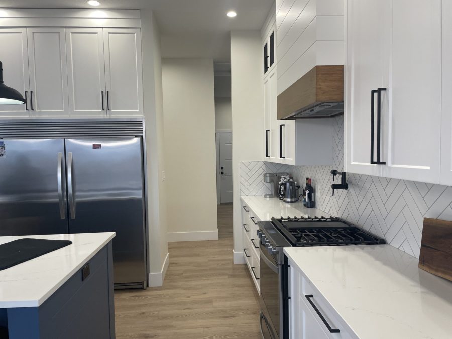 Modern kitchen displaying refinished bright white perimeter cabinets and a contrasting dark island base. Preview Image 6