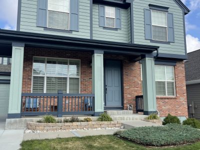 painted house exterior with light seafoam green siding and navy trim