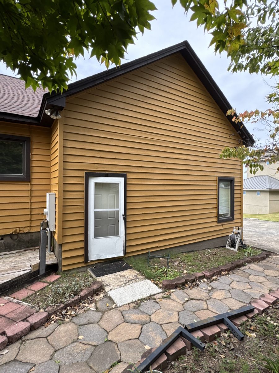 Front corner of a Dadeville lake house after exterior painting with fresh siding color and dark-trimmed windows Preview Image 1
