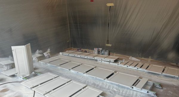 white painted cabinet doors drying on racks