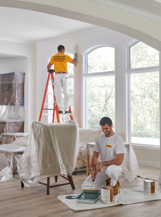Two painters from CertaPro of South Oklahoma City covering repaired drywall and sheetrock in primer.