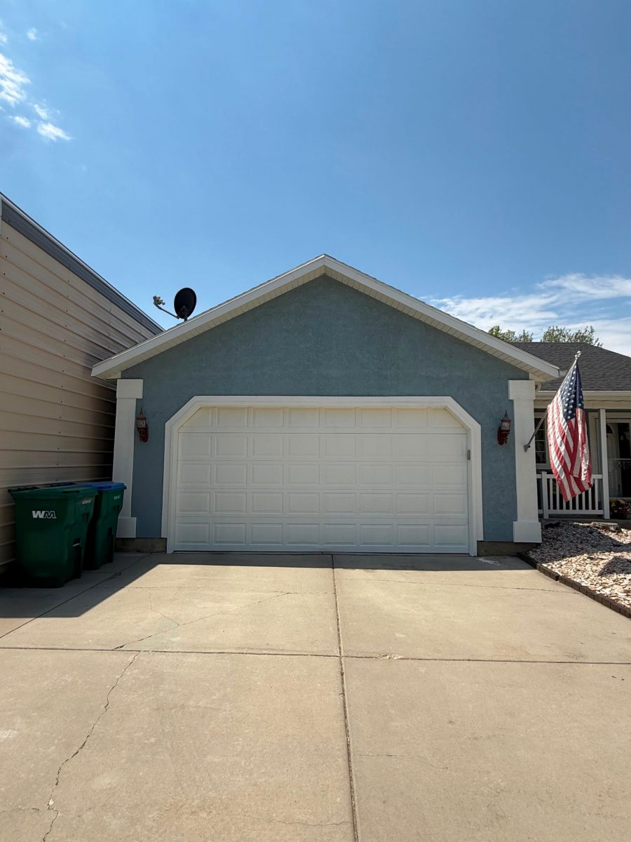 House exterior with painted blue siding and white trim and garage Preview Image 1