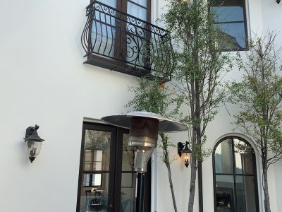 Back of stucco home after being repainted using a spray rig.