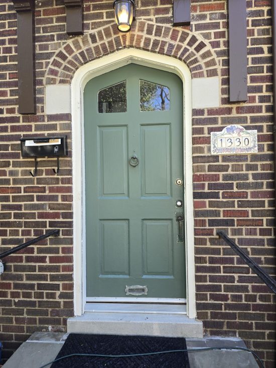 green arched door of brick house