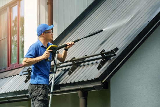Man Power Washing A Home