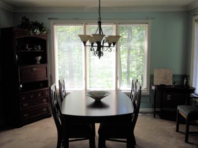 Soft blue-gray dining room in Westdale, ON featuring white crown molding, crisp baseboards, and bright bay window casings.