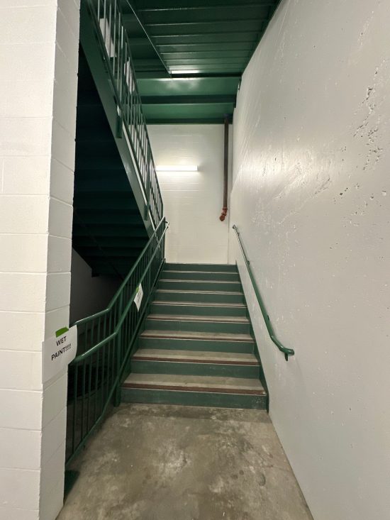 Freshly painted Dayton Dragons stadium stairwell with white walls and green railings