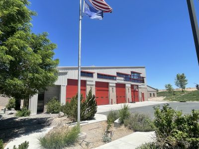 fire station with tan siding and dark red bay doors and trim