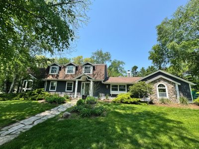 Front exterior of blue painted house and front yard