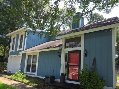 house with blue painted siding, white trim and red door