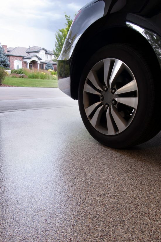 Car tire on top of stained concrete flooring