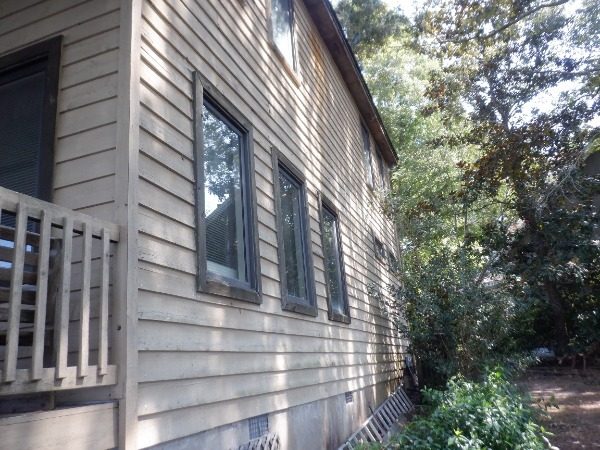 Left side of a Dadeville lake house before exterior painting with aged lap siding and dark window frames Preview Image 8