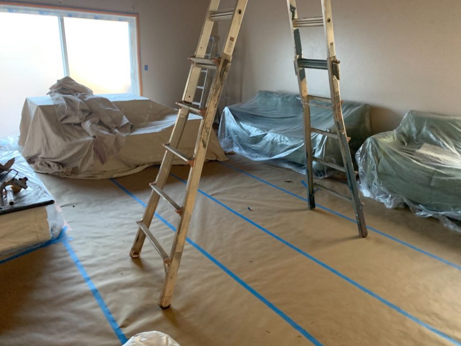 Covering the furniture with drop cloths and plastic before painting. Preview Image 3